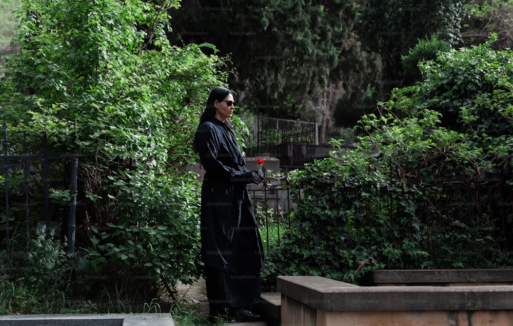 un homme vêtu d’une robe noire debout à côté d’un banc