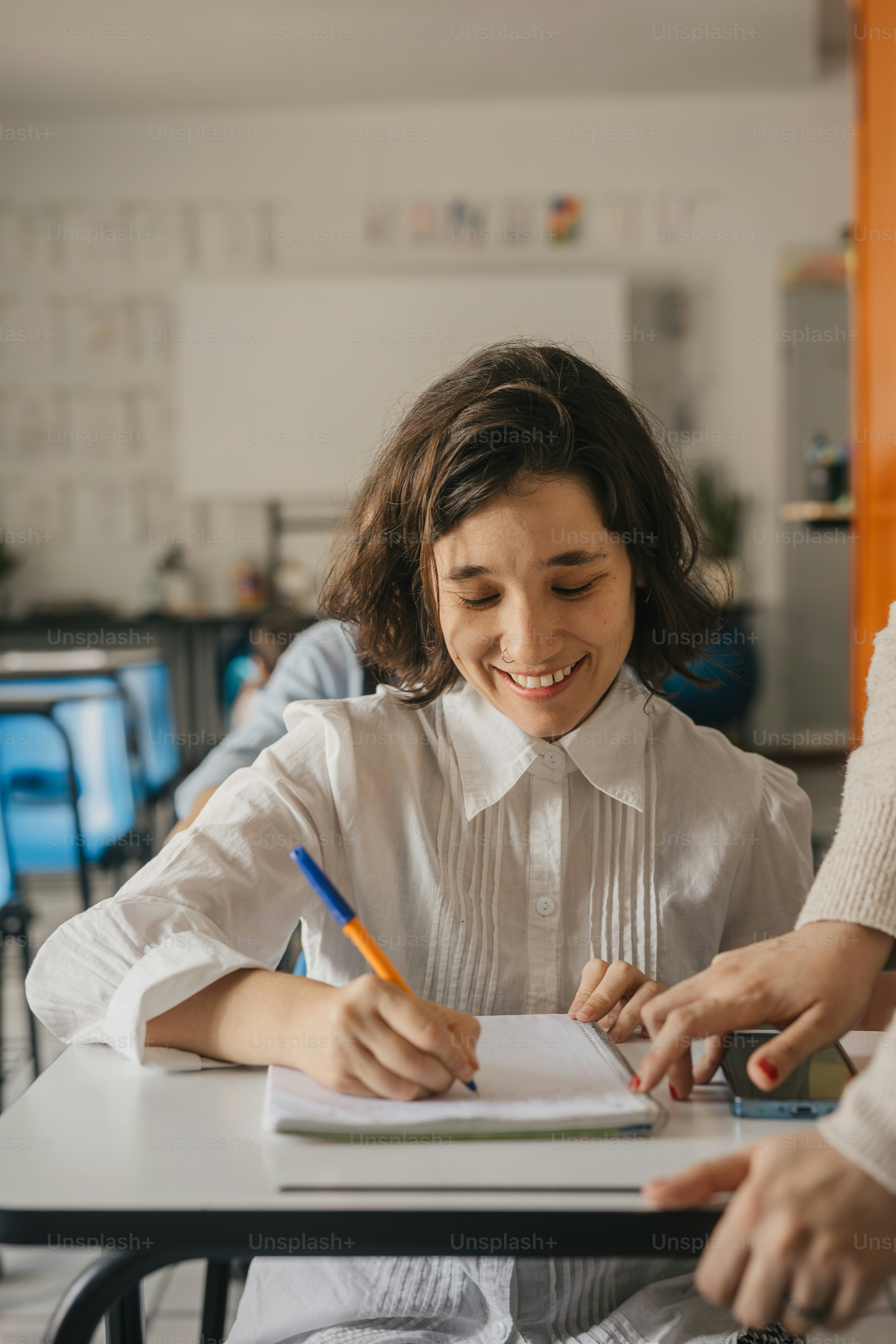 une femme assise à un bureau écrivant sur un morceau de papier