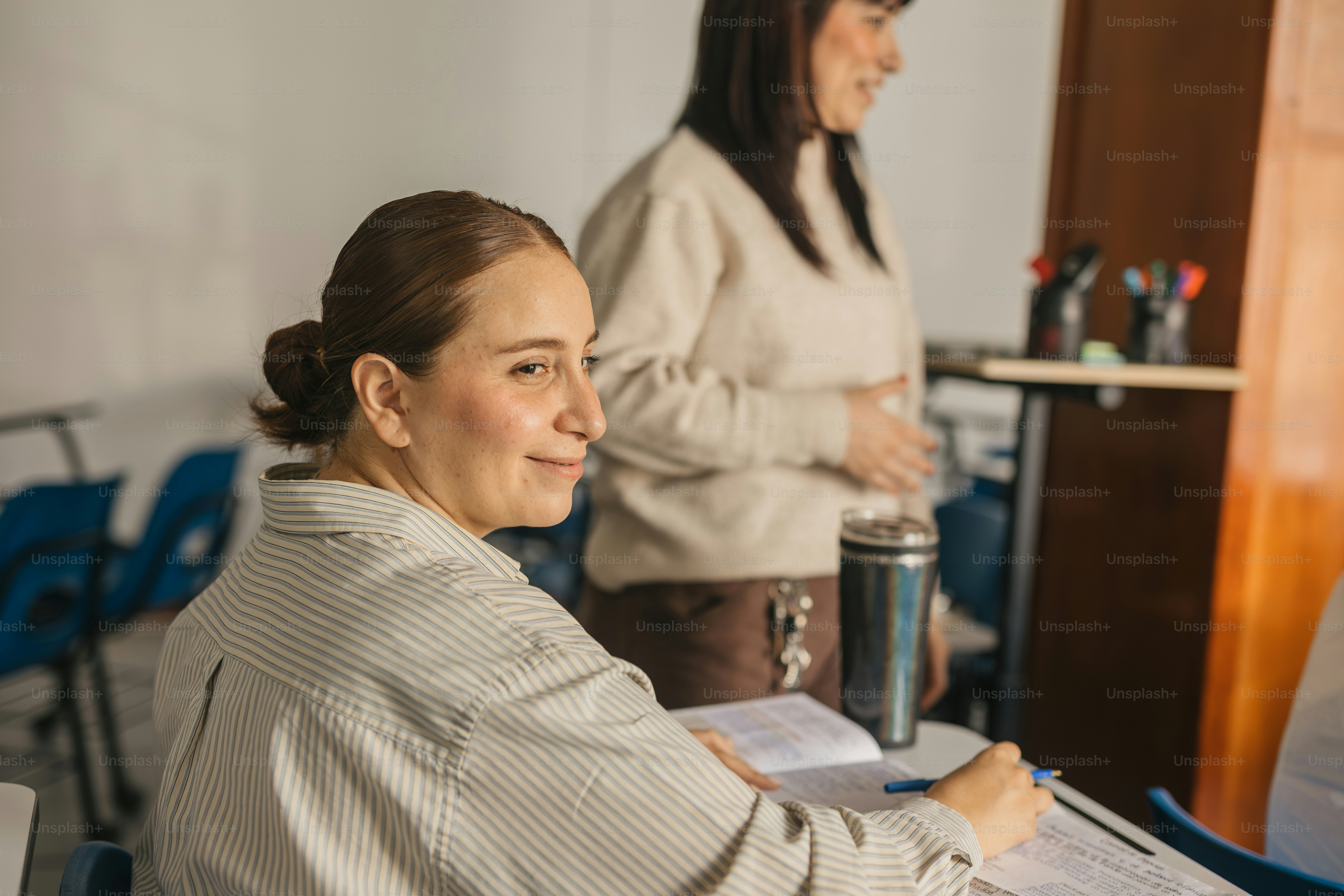 a woman sitting at a desk with a cup of coffee