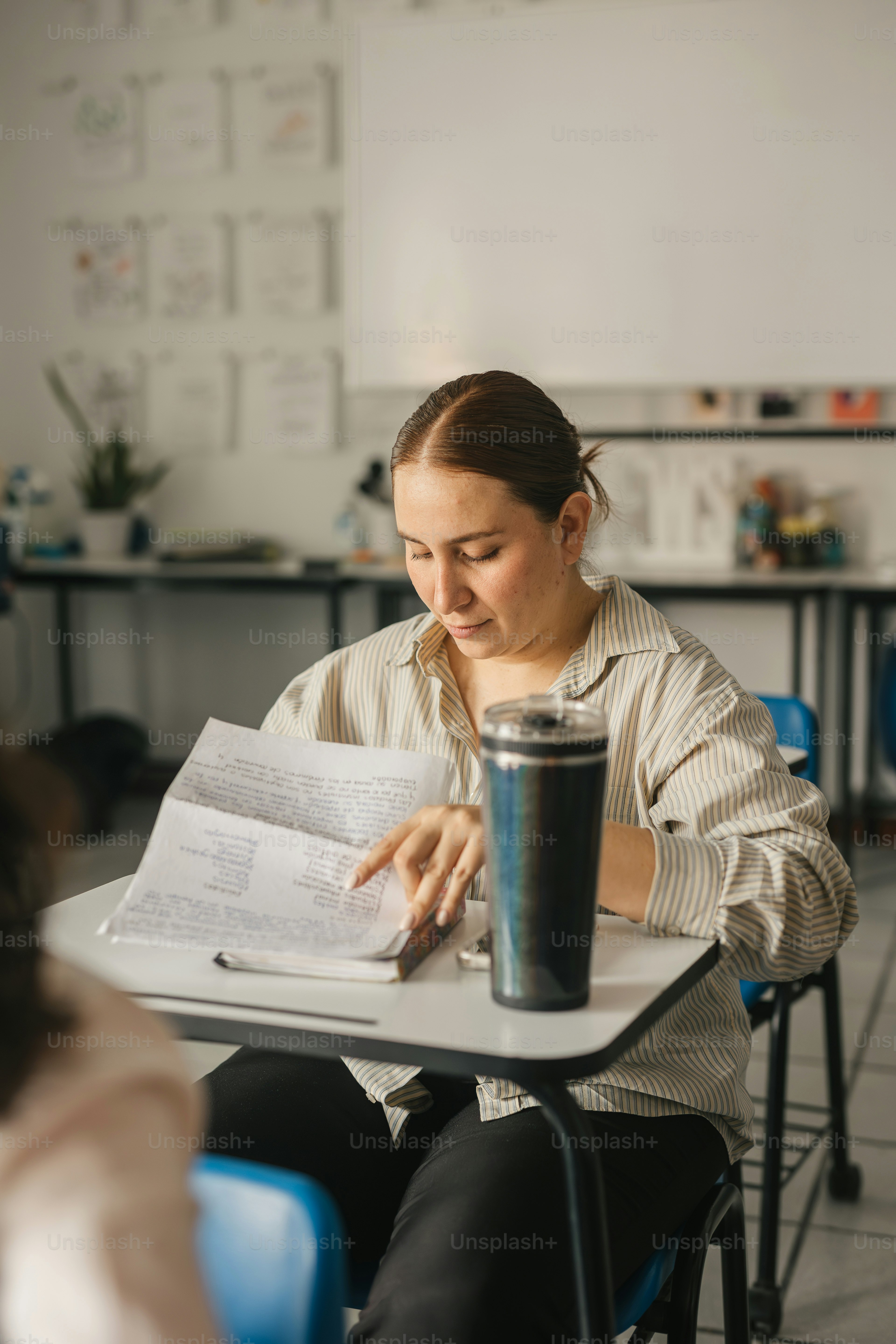 a woman sitting at a table reading a book
