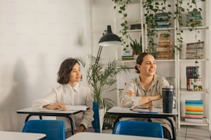 two women sitting at desks in a classroom