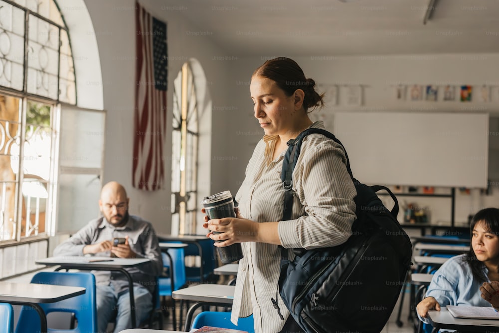 a woman holding a coffee cup in a classroom