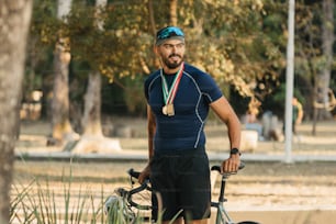 a man with a medal standing next to a bike