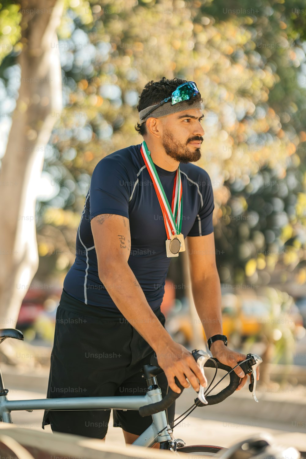 a man is riding a bike with a medal around his neck