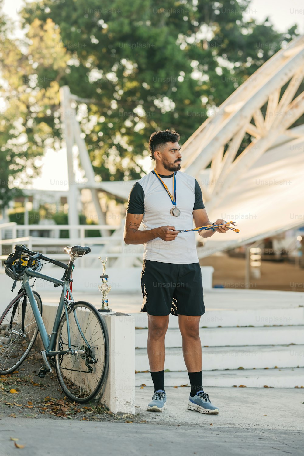 a man standing next to a bike holding a medal