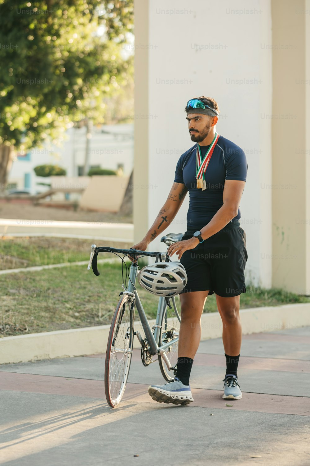 a man with a medal standing next to a bike