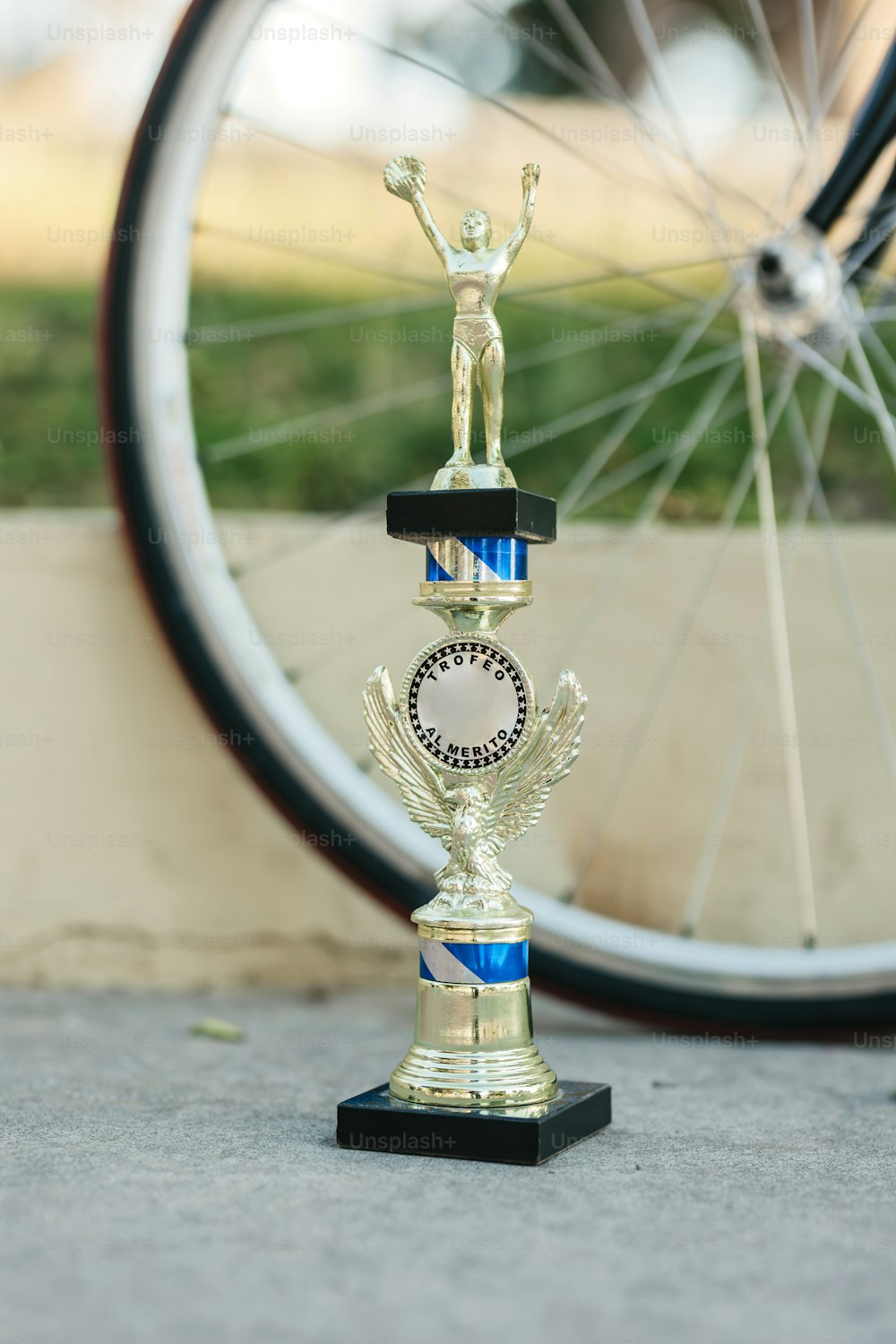 a golden trophy sitting next to a bicycle