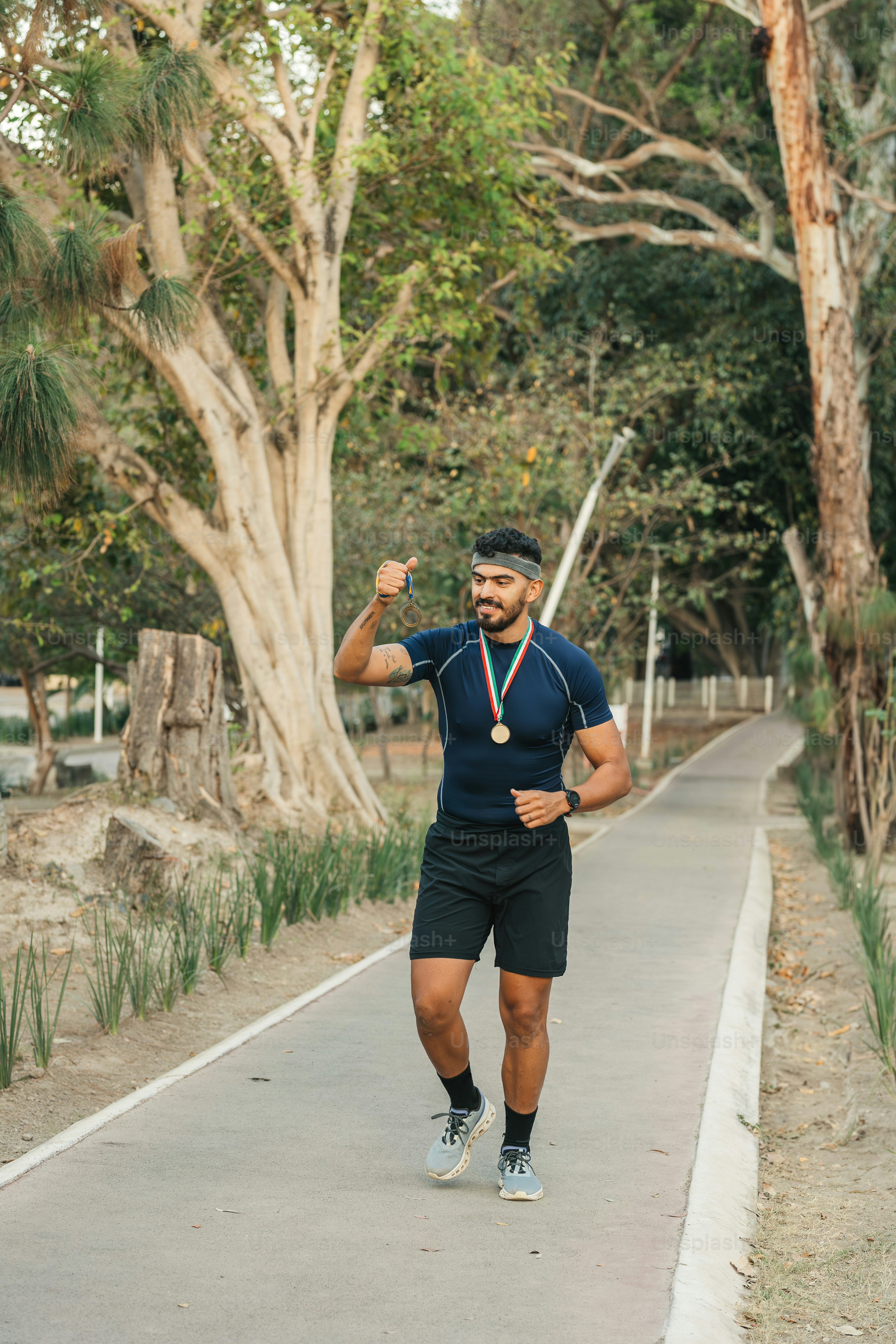 un uomo che corre su un sentiero con alberi sullo sfondo