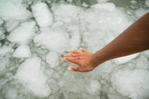 a person reaching for something in a pool of ice