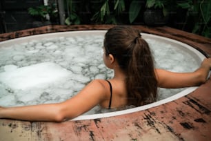 a woman sitting in a large tub of water