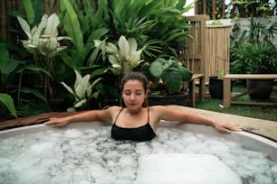 a woman sitting in a bubble bath in a garden