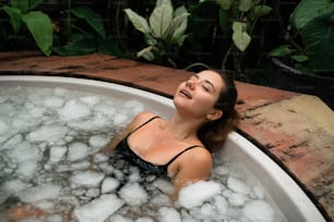 a woman in a bathtub with bubbles in it