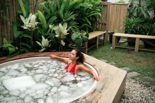 a woman in a hot tub in a backyard