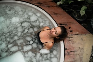 a woman in a bathtub with bubbles around her