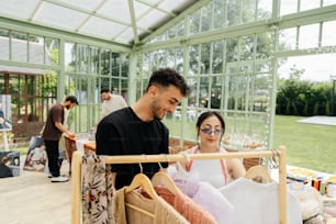 Un hombre y una mujer mirando la ropa en un invernadero