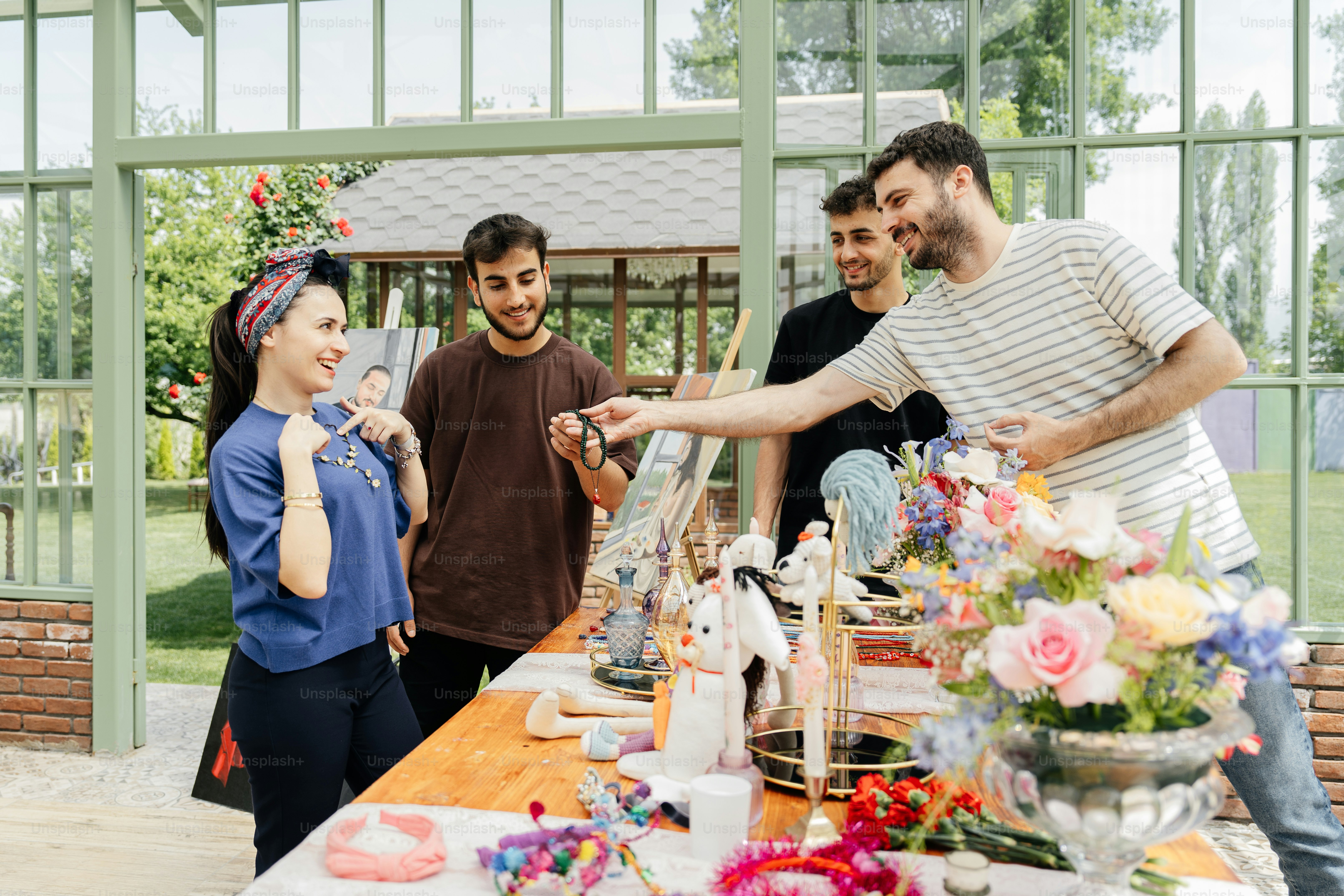 A group of people standing around a table photo – Market Image on Unsplash
