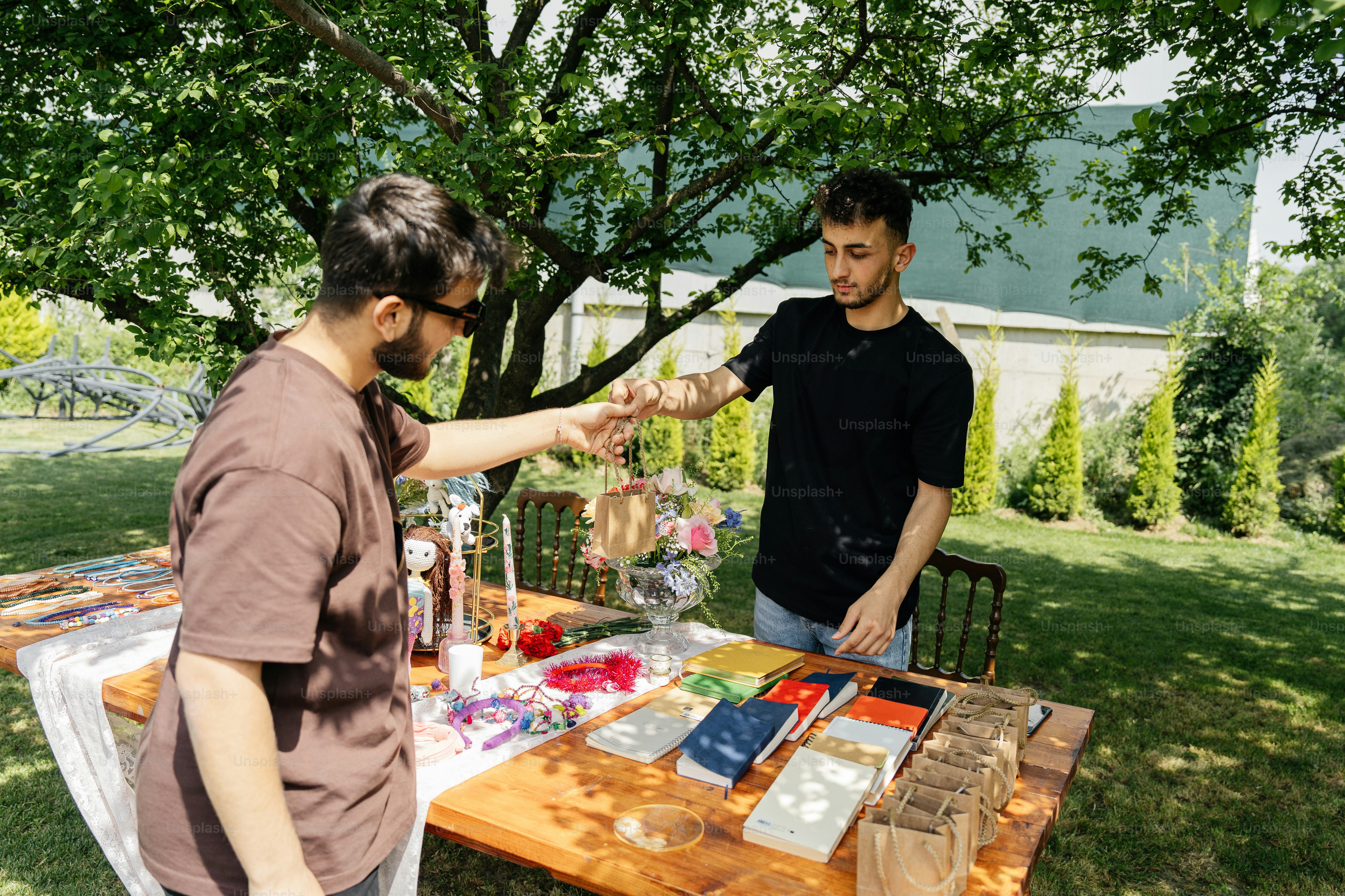 a couple of men standing next to a wooden table