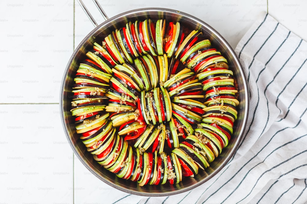 a pan filled with sliced vegetables on top of a table