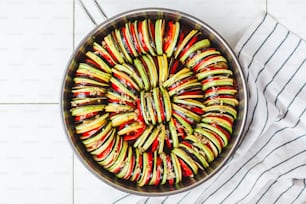a pan filled with sliced vegetables on top of a table