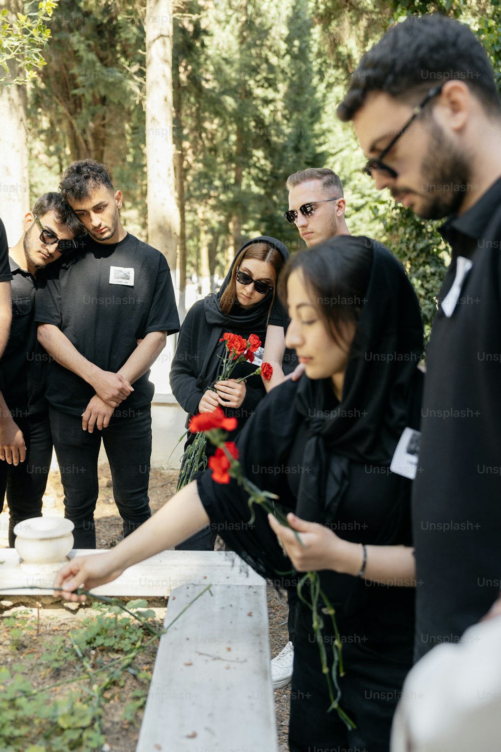 a group of people standing around a grave