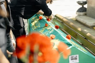 a woman placing flowers on a green table