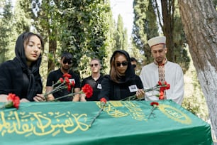 un gruppo di persone in piedi intorno a un tavolo verde