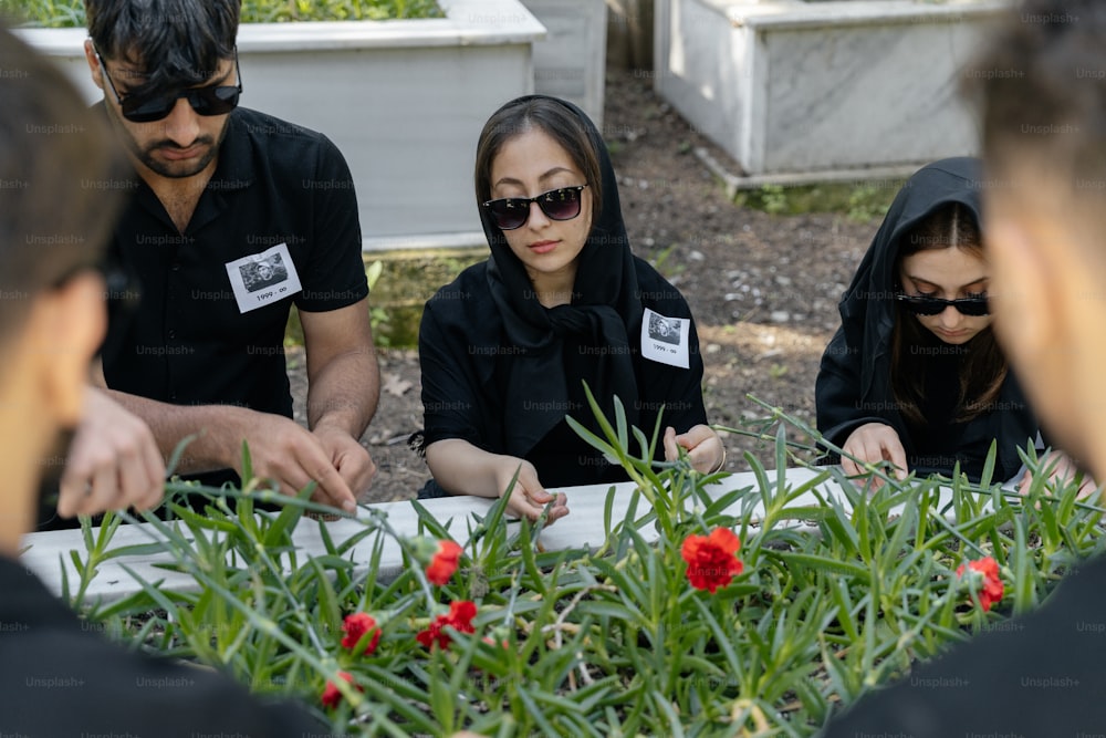 Un grupo de personas sentadas alrededor de una mesa cubierta de plantas