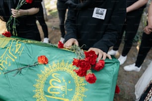 a group of people standing around a green banner