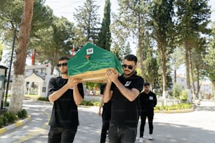 a group of men carrying a large green object