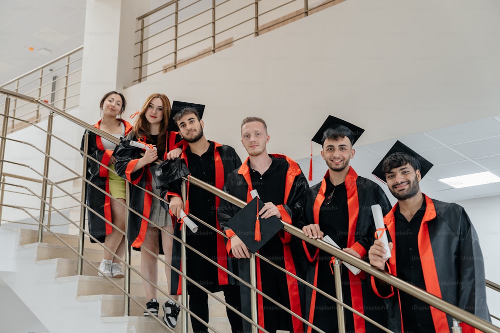 um grupo de graduados em pé sobre uma escada