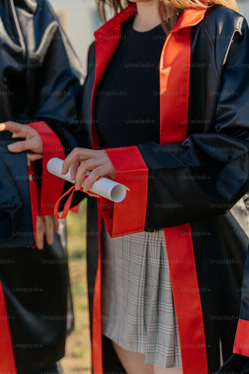 a woman in a black and red graduation gown