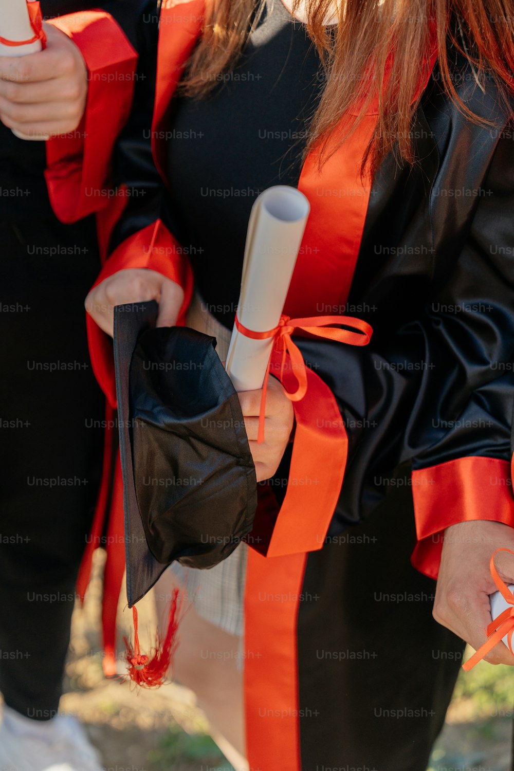 a woman in a black and orange graduation gown
