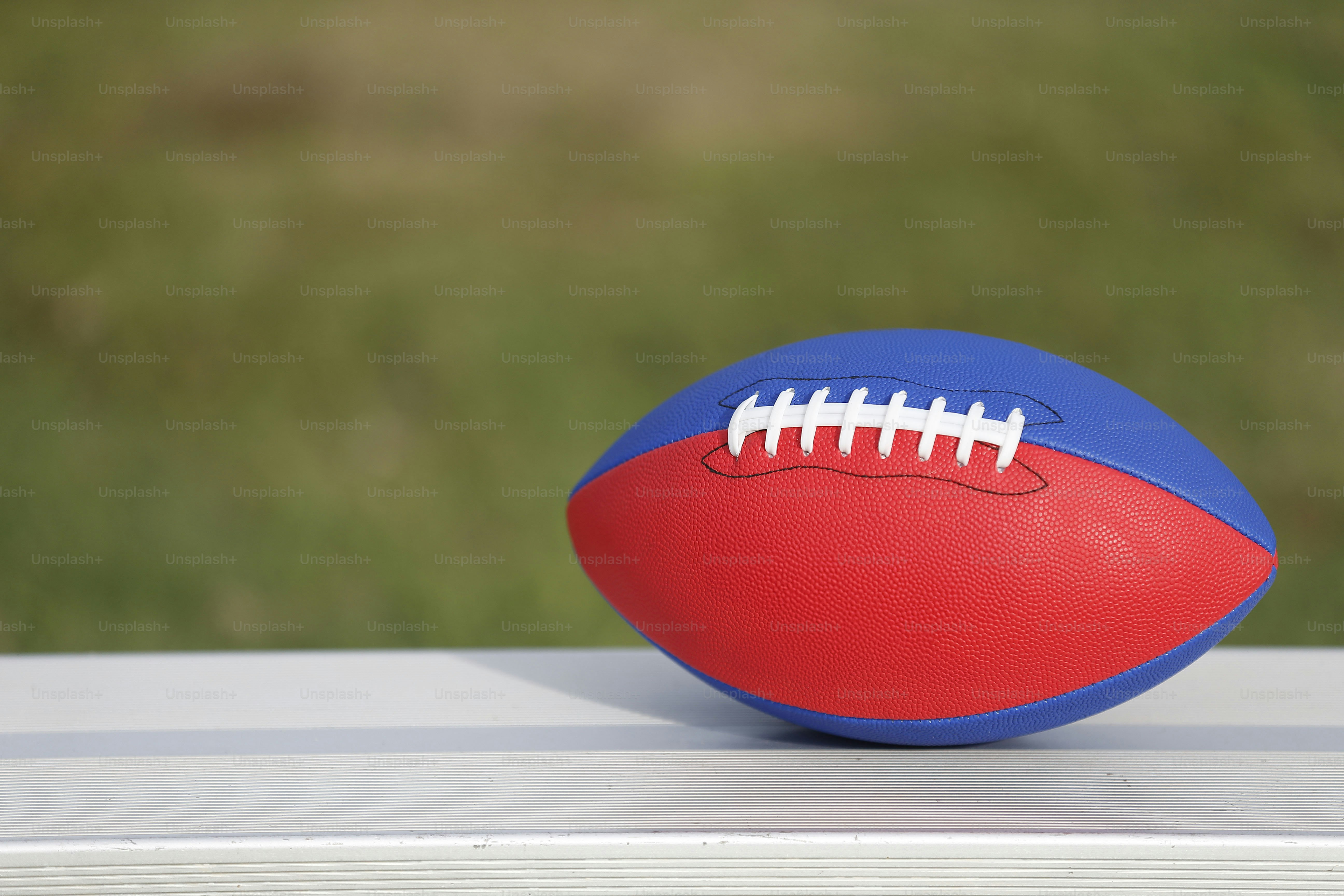 赤と青のフットボールが白い表面に置かれています。