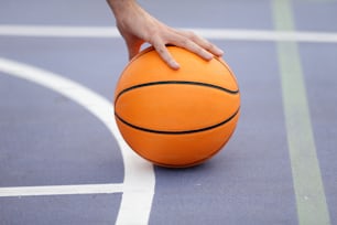 a person holding a basketball on a basketball court