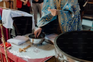 a priest stirring a bowl of food on a table