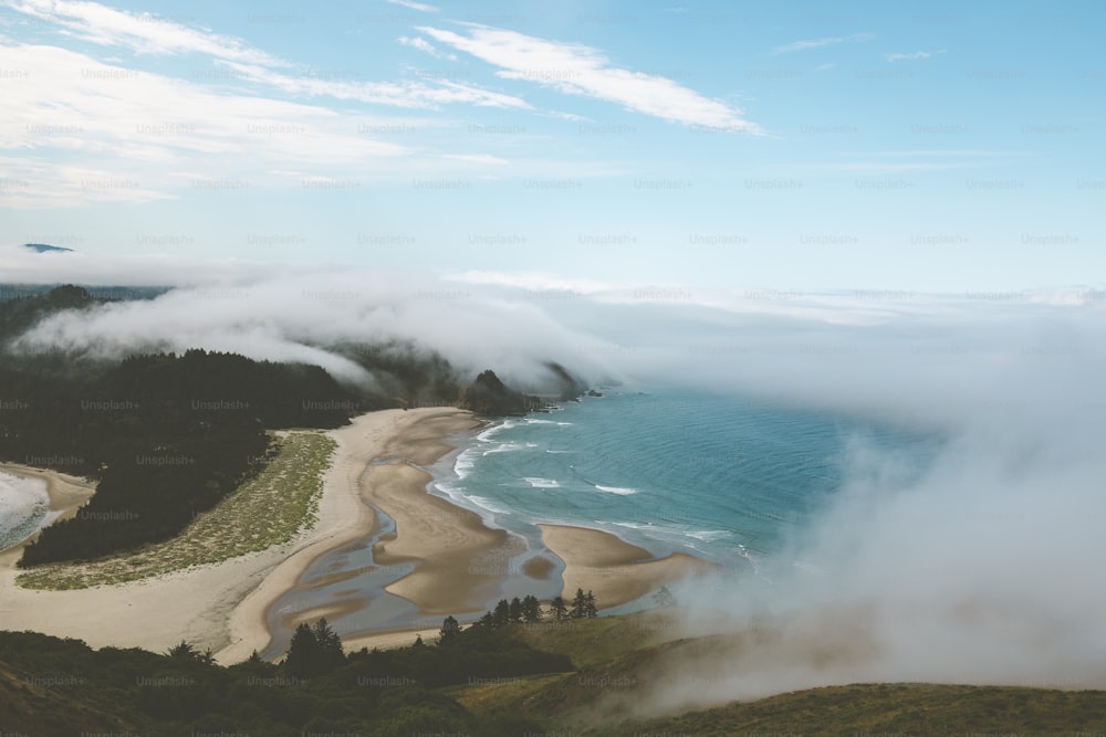 an aerial view of a beach surrounded by clouds