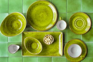 uma mesa verde com pratos e xícaras