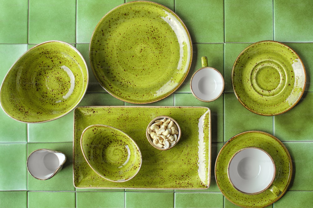 une table verte avec des plats et des tasses