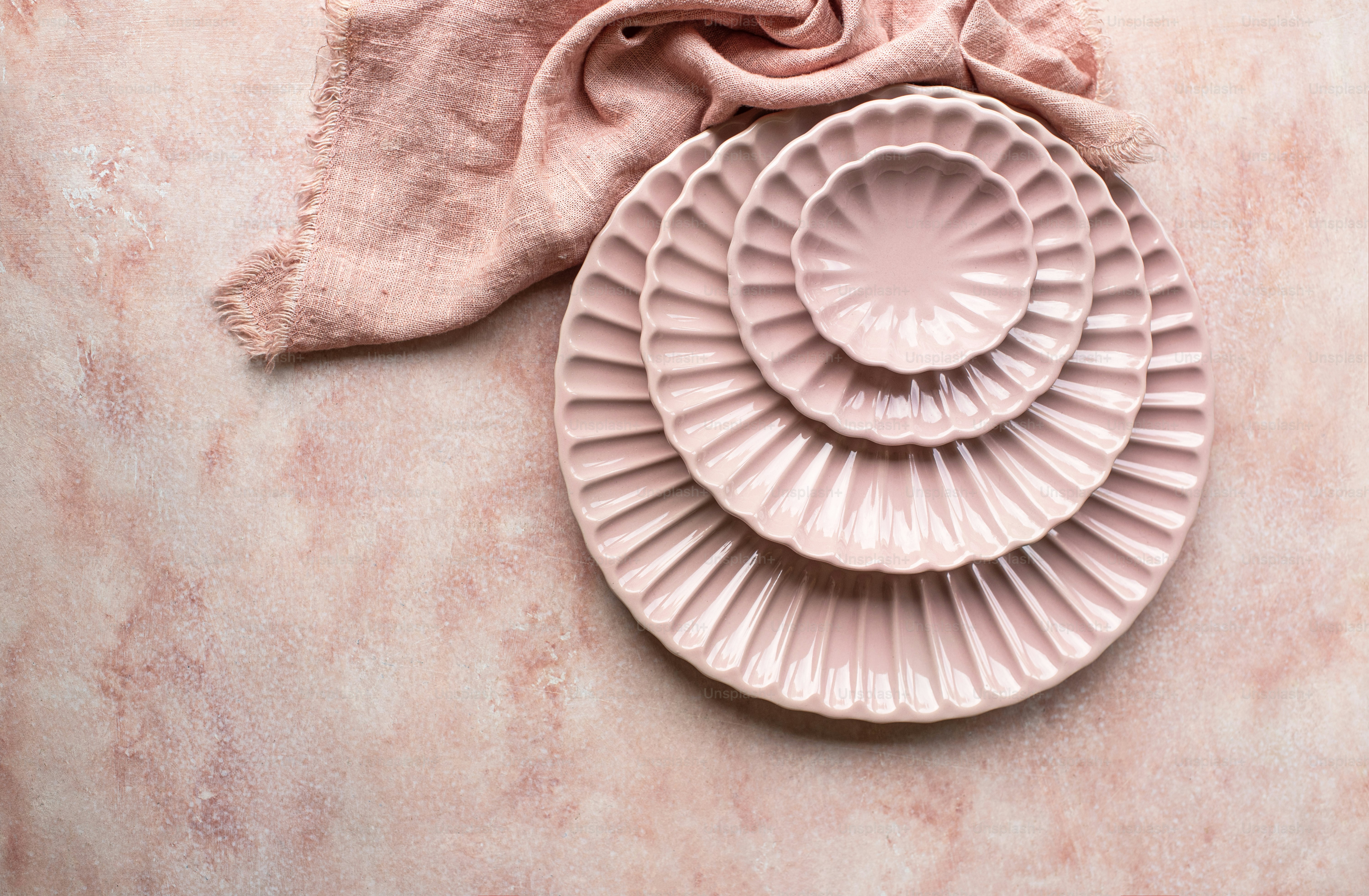 dois pratos cor-de-rosa sentados em cima de uma mesa