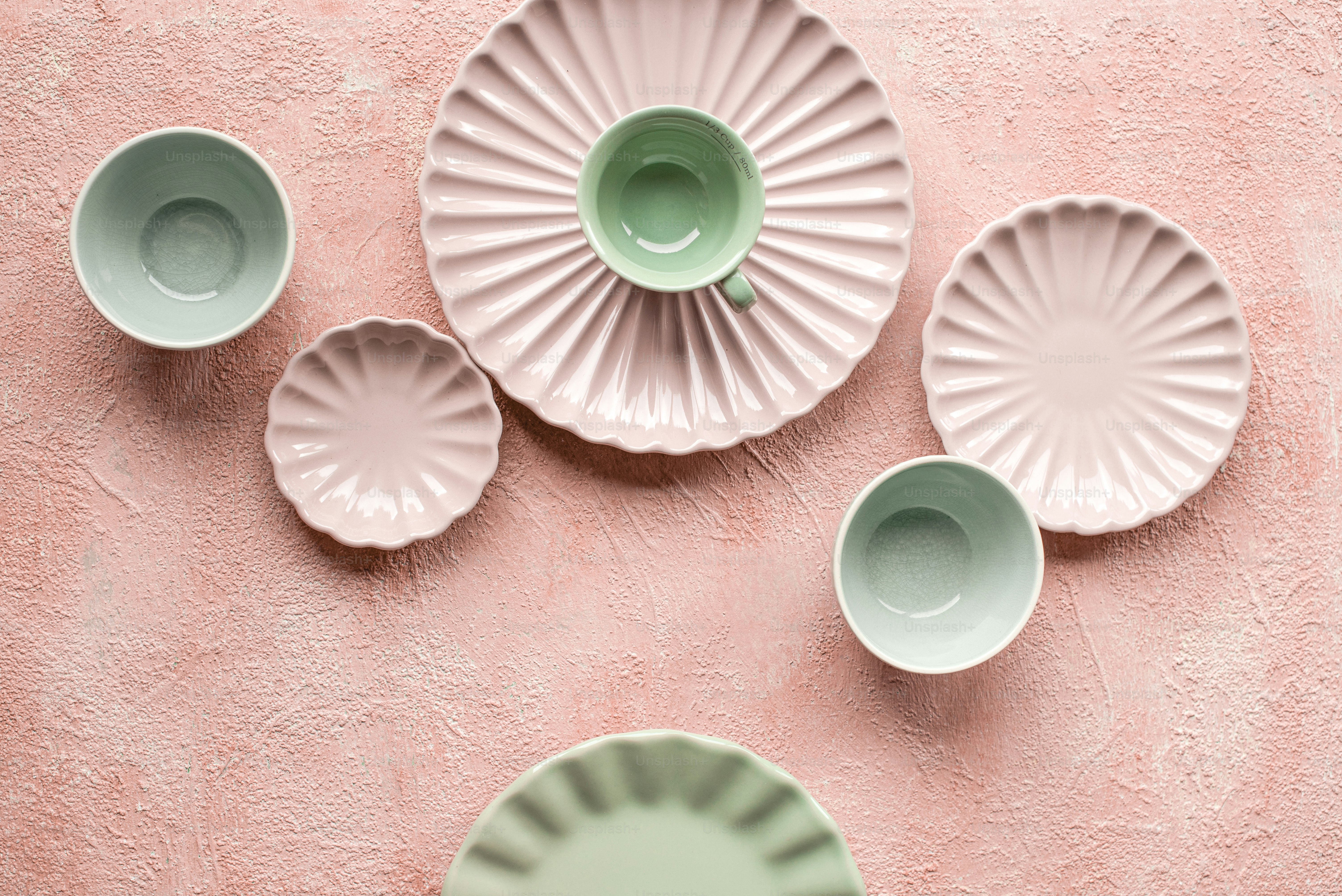 una pared rosa con cinco platos verdes