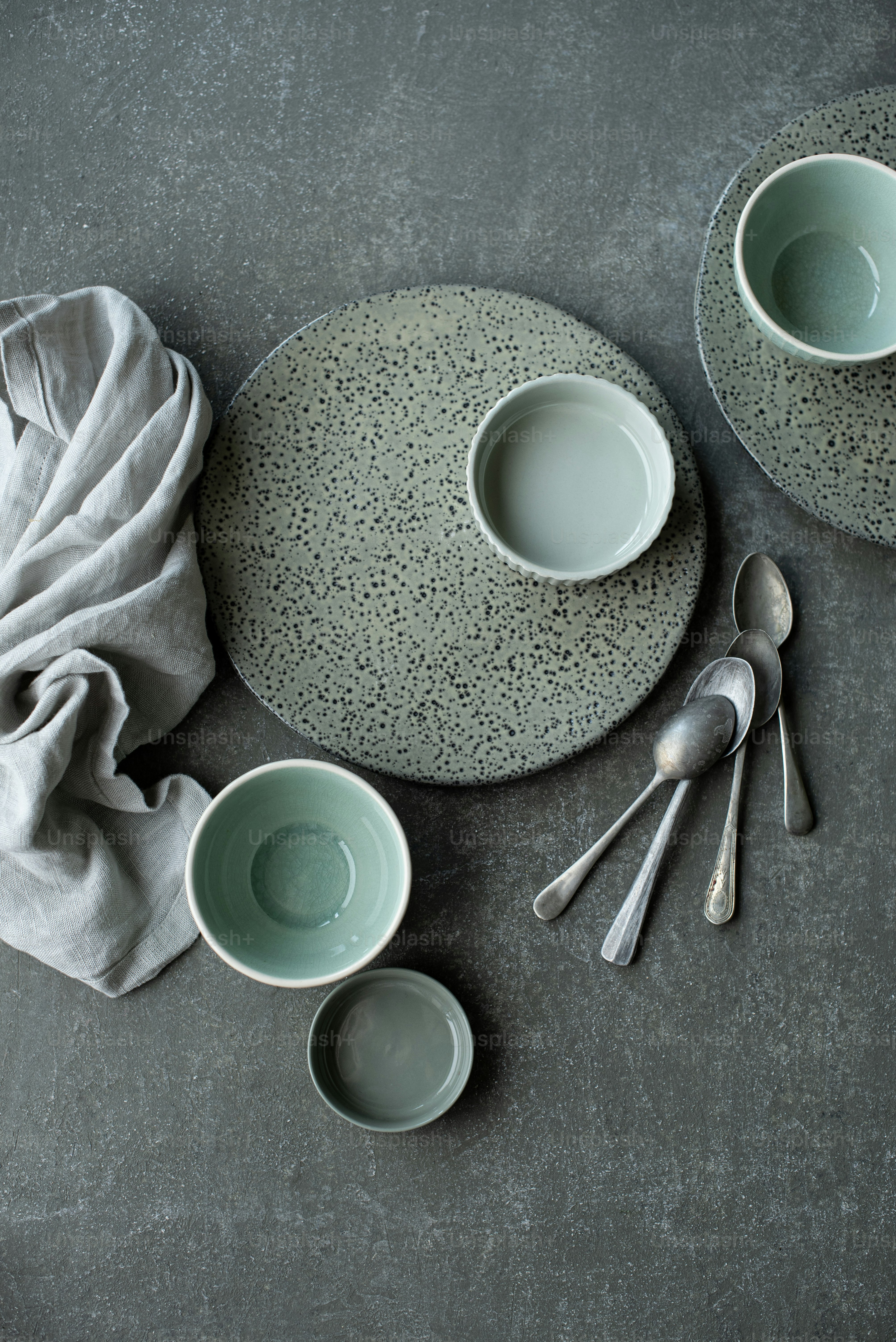 ein Tisch mit Tellern und Schalen neben einer Serviette