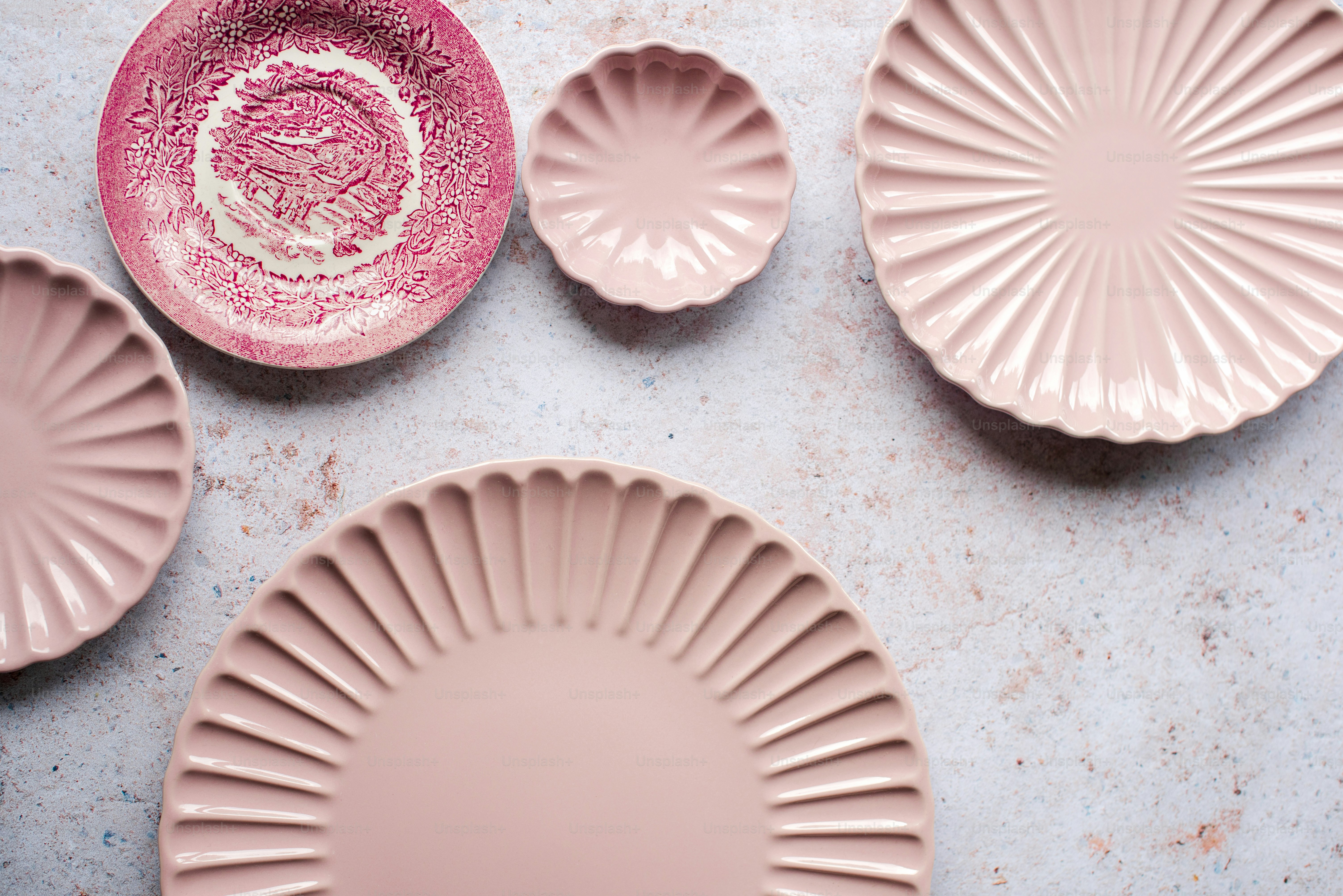 a group of pink plates sitting on top of a table