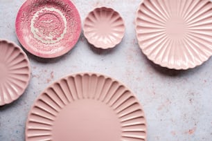 um grupo de pratos cor-de-rosa sentados em cima de uma mesa