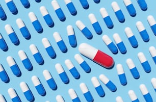 Una gran cápsula de píldoras rojas que interrumpe filas de píldoras azules. Concepto de renderizado 3D.