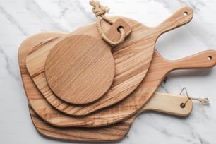 a set of three wooden cutting boards sitting on top of a marble counter