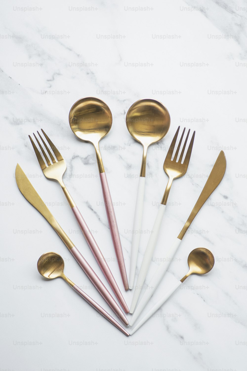 a set of six gold and white utensils
