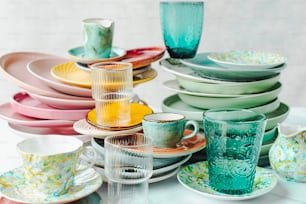 un tavolo sormontato da un sacco di piatti e tazze colorate