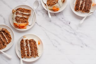 três pratos com fatias de bolo de cenoura sobre eles