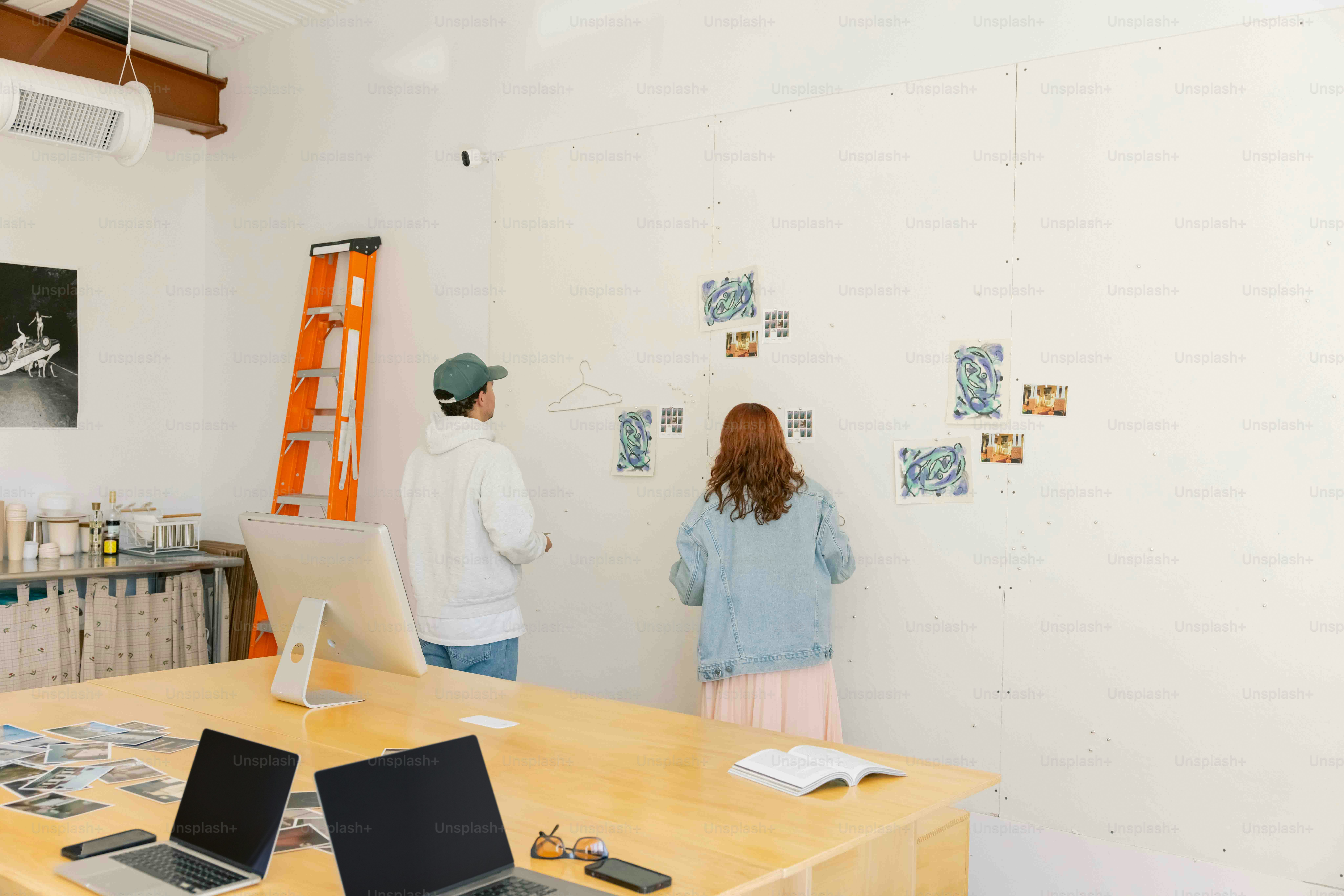 a man and a woman standing in front of a desk with laptops
