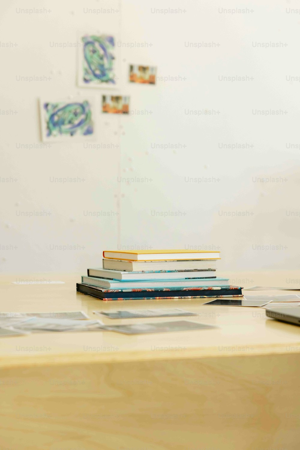 a stack of books sitting on top of a wooden desk